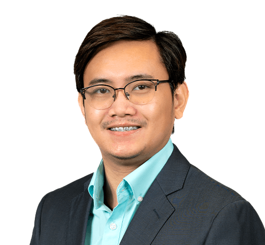 Professional portrait of a man with glasses, wearing a black suit and a light blue shirt, smiling at the camera.