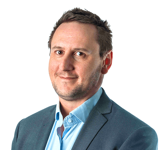 Portrait of a man with short brown hair, dressed in a light blue collared shirt and a dark blazer, against a plain white background.